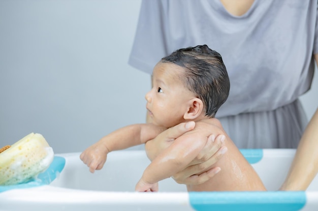Mãe lavando seu bebezinho em um banho