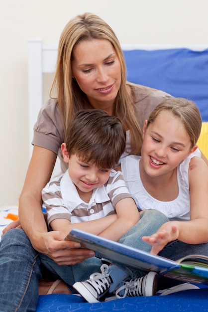 Mãe lendo um livro com sua filha e filho