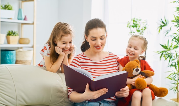 Mãe lendo um livro para filhas