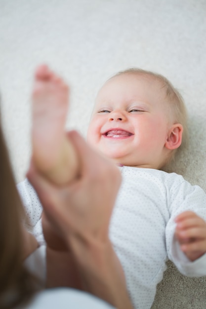 Mãe levantando a perna de um bebê