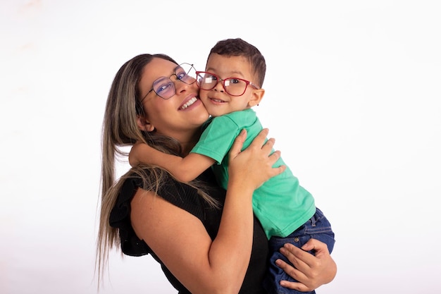 Foto mãe loira com filho nos braços usando óculos em foto de estúdio com fundo branco para recortexa