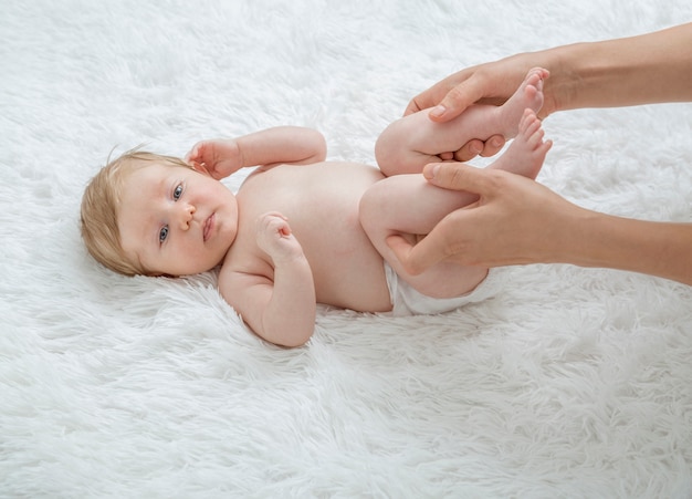 Mãe massageando a barriga do bebê recém-nascido.