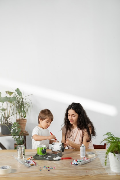 Mãe mostrando ao filho como reutilizar materiais de forma criativa