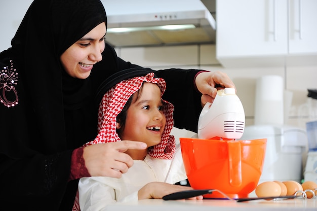 Mãe muçulmana e filho pequeno na cozinha