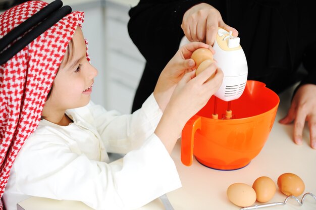 Mãe muçulmana e filho pequeno na cozinha