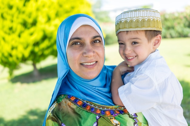 Mãe muçulmana feliz e criança na natureza