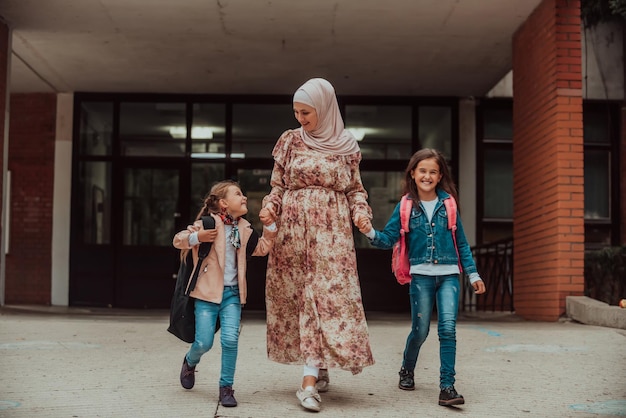 Mãe muçulmana Hijab levando seus filhos para a escola Foco seletivo Foto de alta qualidade