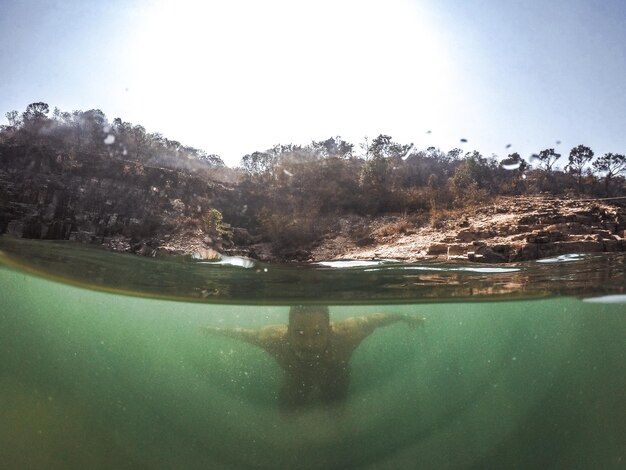 Foto mãe nadando no lago contra o céu claro