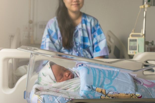 Foto mãe olha para seu bebê recém-nascido na cama imediatamente após um parto. foto do conceito de mulher grávida, recém-nascido, bebê, gravidez.