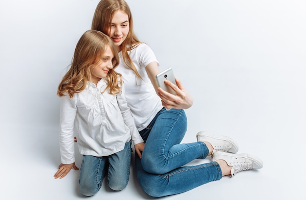 Mãe ou irmã mais velha faz selfie menina, família feliz