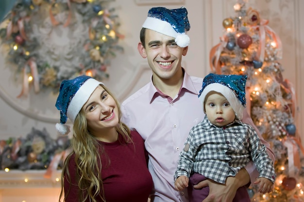 Mãe pai e bebê em chapéus de natal