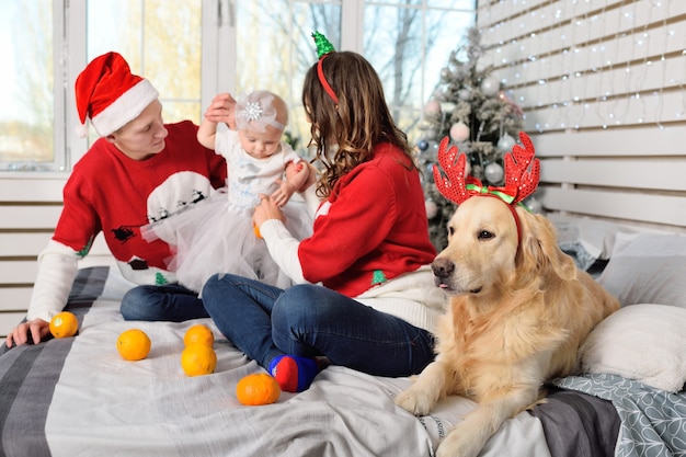 Mãe, pai e filha com suéteres de natal