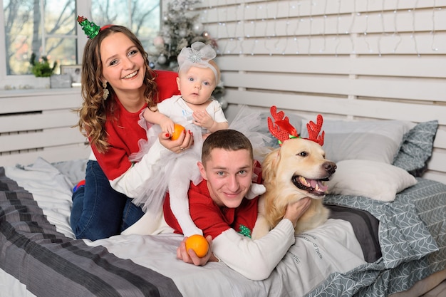 Mãe, pai e filha com suéteres de Natal