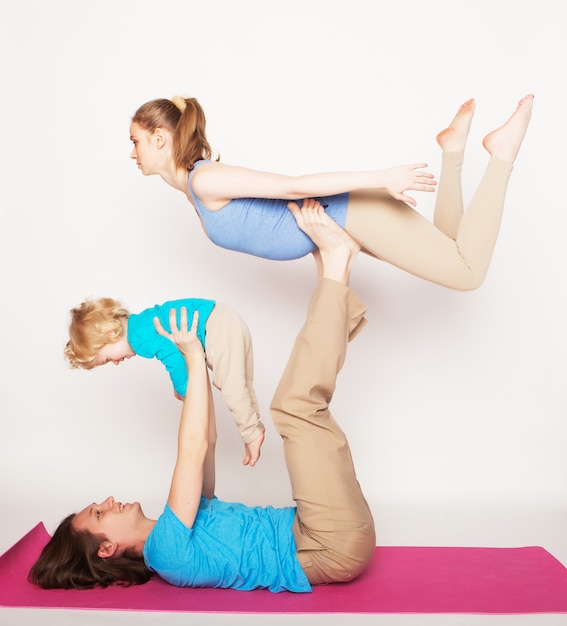 Mãe, pai e filho fazendo yoga