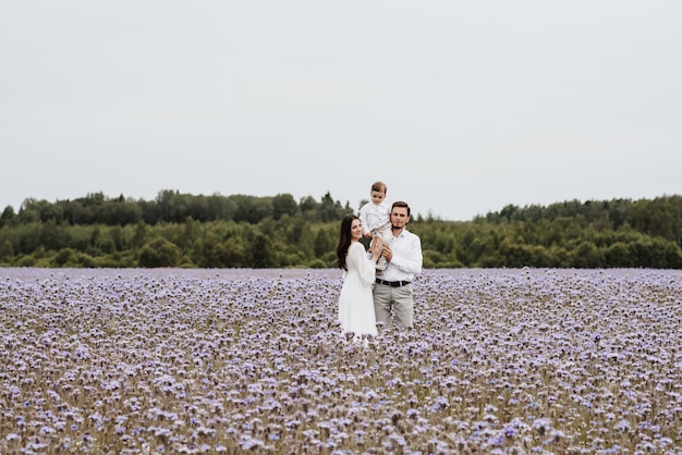 Mãe, pai e filho no fundo de um campo roxo florescendo