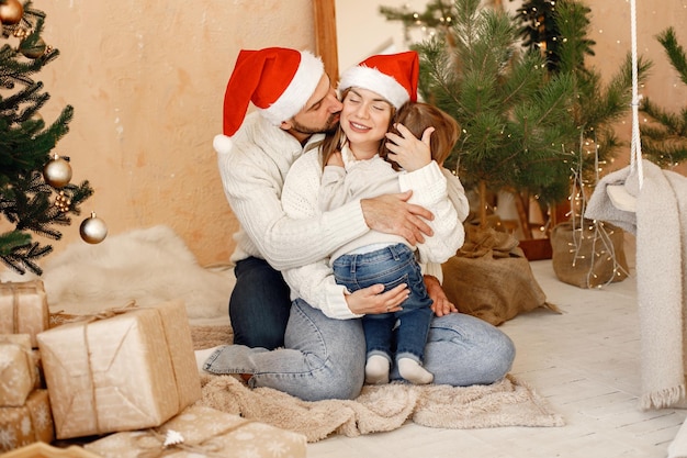 Mãe pai e filho sentado perto da árvore de Natal em casa