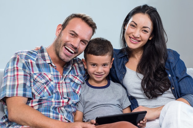 Mãe, pai e filho usando tablet digital