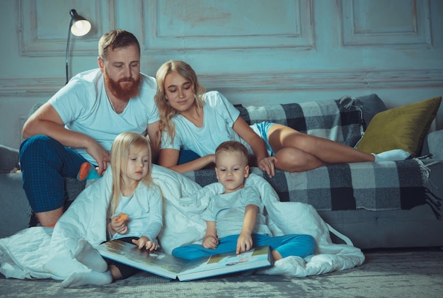 Mãe, pai e filhos em casa se divertindo