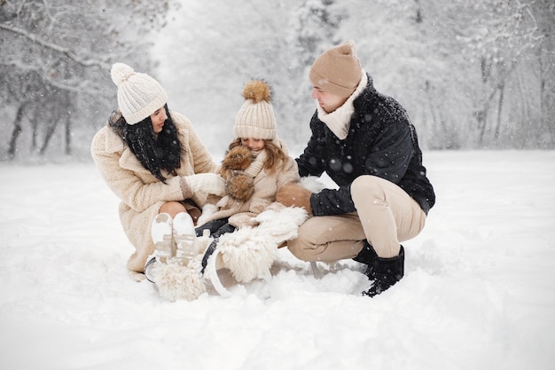 Mãe pai e sua filha brincando ao ar livre no dia de inverno