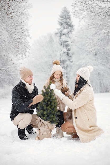 Mãe pai e sua filha brincando ao ar livre no dia de inverno