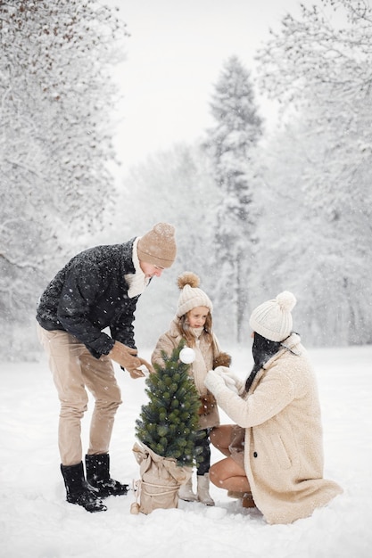 Mãe pai e sua filha brincando ao ar livre no dia de inverno