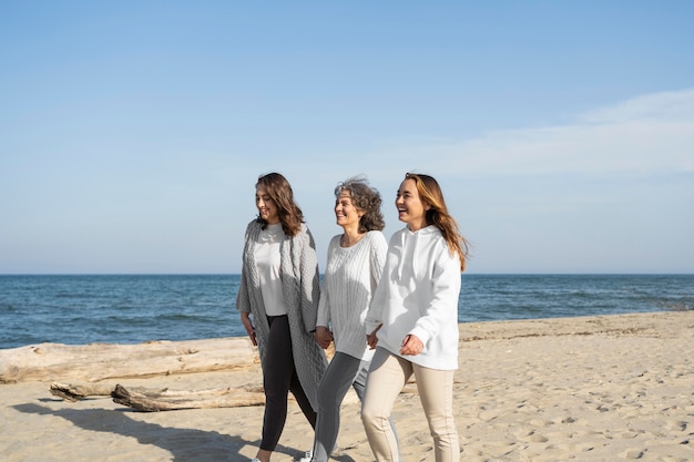 Foto mãe passando um tempo com as filhas na praia