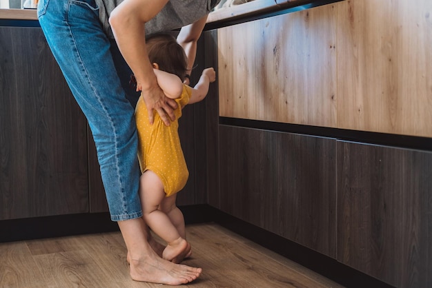 Mãe pegando o bebê com raiva em pé a seus pés mãe e seu bebê