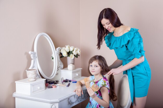 Mãe penteando sua linda filha pré-adolescente