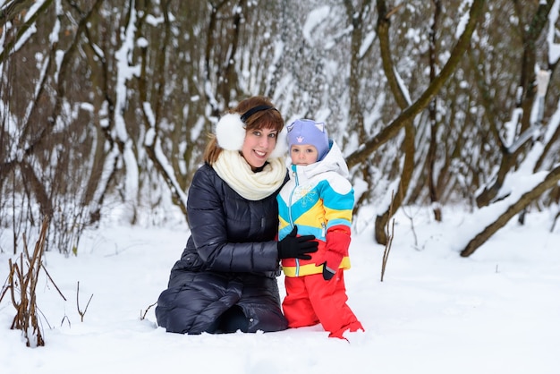 Mãe posando com seu filho na neve