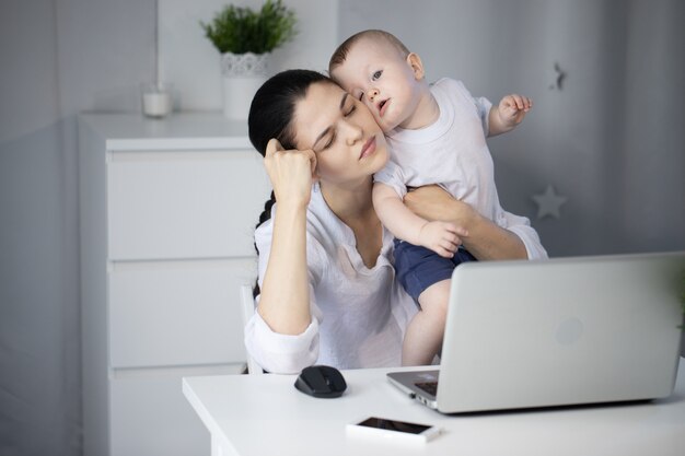 Mãe que trabalha ao lado de seu filho bebê