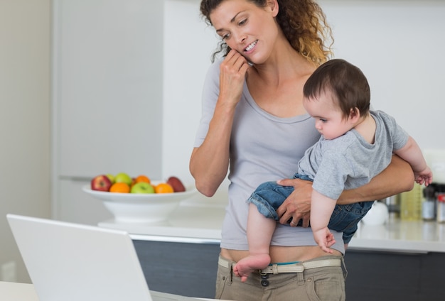 Mãe, responder, cellphone, enquanto, carregar, bebê