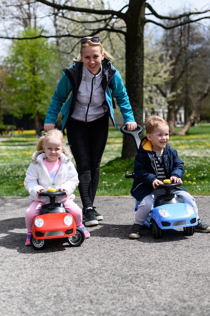 Mãe rola seus filhos em um carro de brinquedo