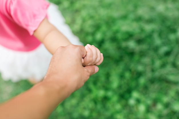 Foto mãe segura a mão do bebê. imagens para o conceito de amor, vínculo e família.