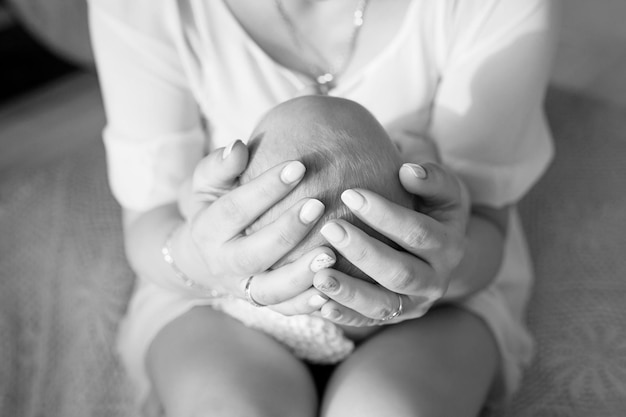 Mãe segurando a cabeça de seu filho recém-nascido nas mãos o bebê nas mãos da mãe