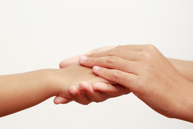 Mãe segurando a mão da filha para mostrar amor e carinho às crianças