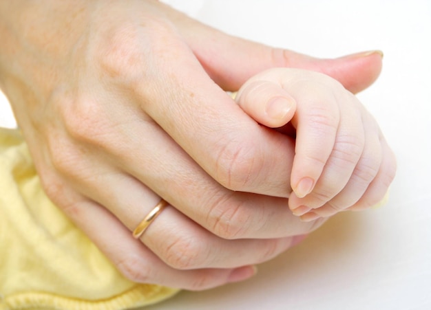 Mãe segurando a mão de um bebê