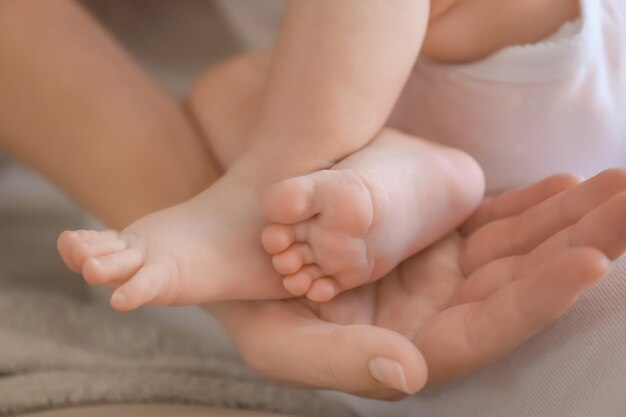 Mãe segurando as pernas do bebê em casa