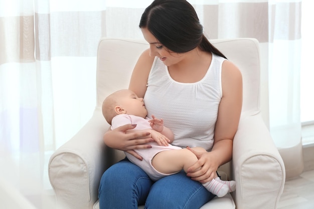 Mãe segurando bebê dormindo em casa