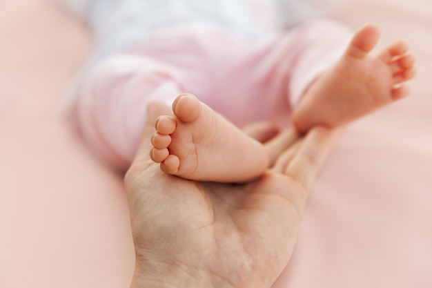 Mãe, segurando, bebê recém-nascido, menina, pés