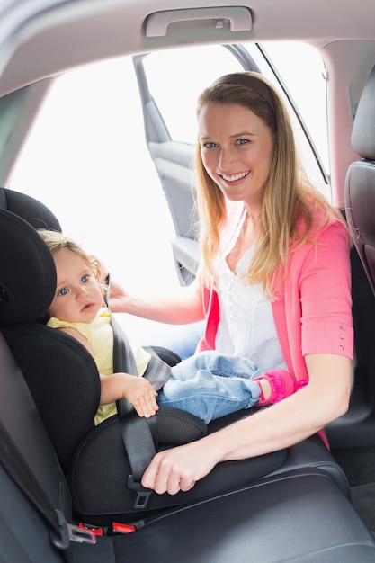 Mãe segurando seu bebê no assento do carro