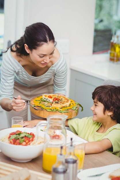 Mãe servindo comida para o filho