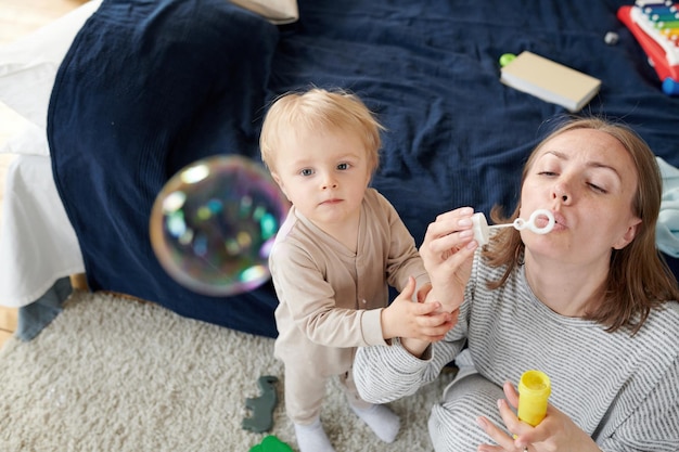 Mãe soprando bolhas com criança