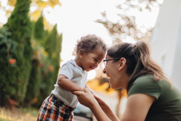Mãe sorridente com filho brincando ao ar livre