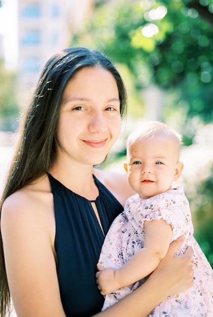 Mãe sorridente com uma garotinha nos braços