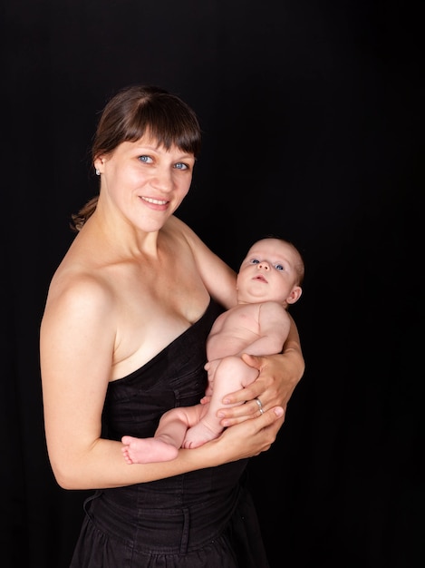 Mãe sorridente e amorosa segurando lindo filho na maternidade de braços
