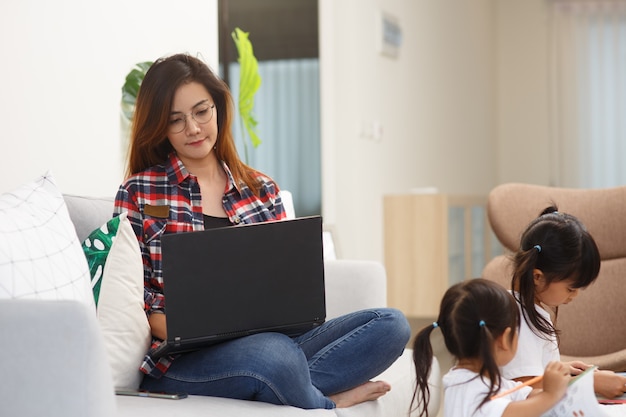 Mãe trabalhando em casa com crianças. quarentena e escola fechada durante surto de coronavírus. as crianças fazem barulho e incomodam a mulher no trabalho. ensino doméstico e trabalho freelance.