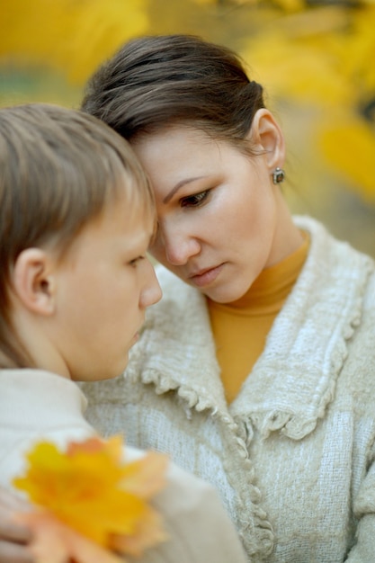 Mãe triste com filho em um passeio no parque de outono