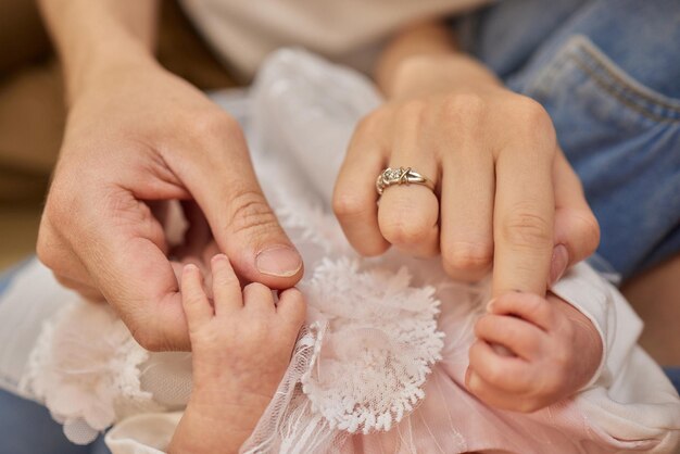 Mãe usa a mão para segurar a mãozinha de seu bebê para fazê-lo sentir seu amor quente e seguro