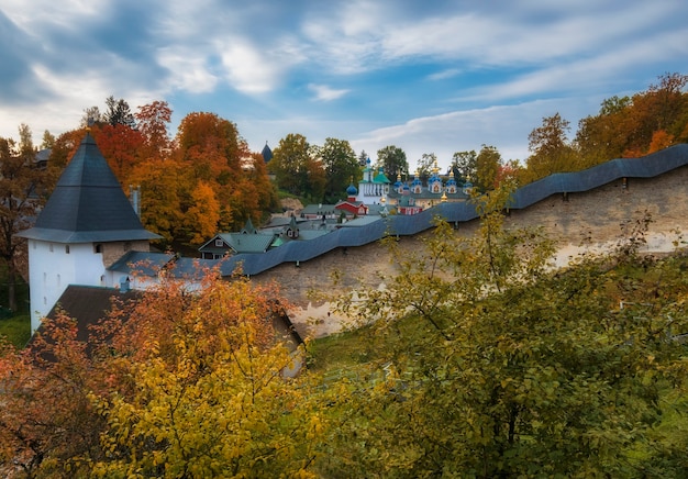 Mächtige Verteidigungsmauern und schöne Kirchen im Kloster Dormitio Pskovo Pechersky in der Stadt Pechery, Region Pskow, Russland während des goldenen Herbstes