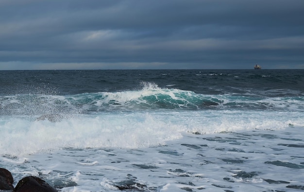 Mächtige Wellen, die an einem felsigen Strand zermalmen